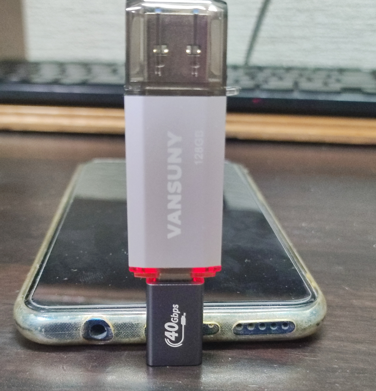 ケースを付けたスマホに、L字の変換アダプタをはさんでVansuny USBメモリを挿したところ
